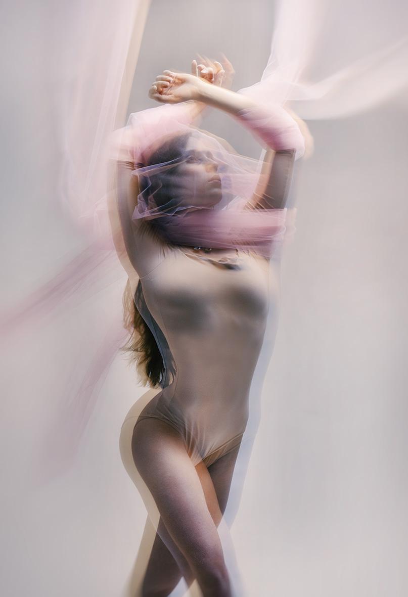 Hannah Martin moving through translucent pink fabric in a studio photograph