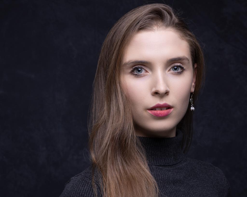 Recent professional portrait of Hannah Martin in a black roll-neck top